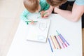 Top view of father and son drawing house together