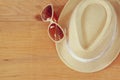 Top view of fedora hat and sunglasses over wooden table. relaxation or vacation concept