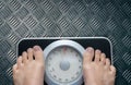 Top view of feet on weighing scale. Women weigh on a weight balance scale after diet control. Healthy body weight. Weight and fat