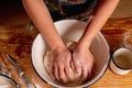 Top view of female baker prepares the dough for baking on kitchen wooden table. Selective focus on hands Royalty Free Stock Photo