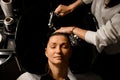 top view on female client relaxed lying on hair washing chair with her eyes closed while hairdresser washes her hair Royalty Free Stock Photo