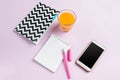 The top view on female desk. The phone and french macarons on trendy pink desk.