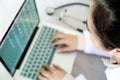 Top view,female doctor working on desk with laptop computer and stethoscope,closeup health professional using a laptop with Royalty Free Stock Photo