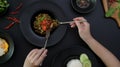 Female eating Stir fried minced pork with basil Pad ka prao, fried egg and chili fish sauce on black dinning table Royalty Free Stock Photo