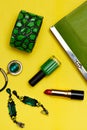 Top view of female fashion accessories . Green handbag with lipstick bracelet earnings necklace Royalty Free Stock Photo