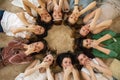 Top view female friends hiding mouth by hands laughing relaxing lying circle together at hen-party Royalty Free Stock Photo