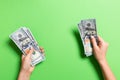 Top view of female hand giving some money, Close-up of counting one hundred dollar bills. Business concept on colorful background