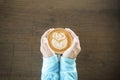 Top view of female hand holding hot coffee latte art rose foam in symbol of love in valentine festival on wooden table at coffee Royalty Free Stock Photo