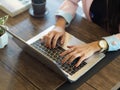 Female hand typing on laptop keyboard on wooden table Royalty Free Stock Photo
