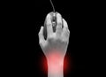 Top view of female hands clicking computer mouse isolated on black background with red spot on her wrist. wrist pain. Carpal Royalty Free Stock Photo