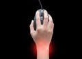 Top view of female hands clicking computer mouse isolated on black background with red spot on her wrist. wrist pain. Carpal Royalty Free Stock Photo