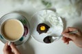 Top view female hands holding cup of tea and fork to eat cake on white table Royalty Free Stock Photo