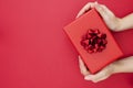 Top view of female hands holding gift box with red ribbon bow isolated over flat lay background, copy space Royalty Free Stock Photo