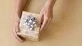 Top view of female hands holding present box package in the palms isolated over flat lay background Royalty Free Stock Photo