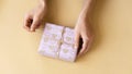 Top view of female hands holding present box package in the palms isolated over flat lay background Royalty Free Stock Photo