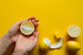 Top view of female hands holding whole and sliced ripe lemons on a yellow surface, concept of health and vitamins Royalty Free Stock Photo