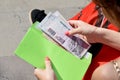 Top view of female hands in red dress putting Egyptian pounds in green envelope Royalty Free Stock Photo