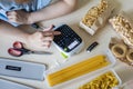 Top view female hands use labeler electronic device for marking different pasta closeup POV shot