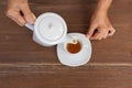 Top view of a female pouring tea on wooden table Royalty Free Stock Photo