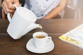 Top view of a female pouring tea on wooden table Royalty Free Stock Photo