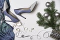 Top view female stylish accessories fashion outfit: blue cloth, shoes earrings necklace silver ribbon branches fir tree on white Royalty Free Stock Photo