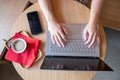 Top view of female using her laptop at a cafe. Overhead shot of young woman sitting at a table with a cup of coffee and Royalty Free Stock Photo