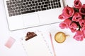 Top view of female worker desktop with laptop, flowers and different office supplies items. Feminine creative design workspace. Royalty Free Stock Photo