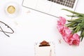 Top view of female worker desktop with laptop, flowers and different office supplies items. Feminine creative design workspace. Royalty Free Stock Photo