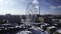 Top view of Ferris wheel in city center in winter. Creative. Large Ferris wheel stands in city on sunny winter day. Non