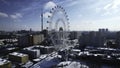 Top view of Ferris wheel in city center in winter. Creative. Large Ferris wheel stands in city on sunny winter day. Non