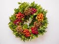 Top view of a festive Christmas wreath with red and orange berries on a white background. Royalty Free Stock Photo