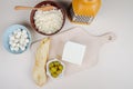 top view of feta cheese with pickled olives on a wooden cutting board and string cheese , cottage cheese in a bowl and mozzarella Royalty Free Stock Photo