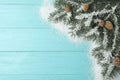Top view of fir branches and snow on light blue wooden background, space for text. Winter holidays Royalty Free Stock Photo