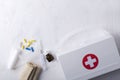 Top view of first aid kit on the white surface.Plastic white medicine bag, pills, bandage and syringe.Empty space for text Royalty Free Stock Photo