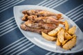 Top view of fish and chips. Fried fish and potato slices on a white plate. Plate on the table with a blue tablecloth in Royalty Free Stock Photo