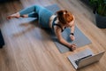 Top view of fit redhead young woman working out, doing stretching exercise on yoga mat