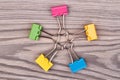 Top view five colorful binder clips on white wooden desk. Royalty Free Stock Photo