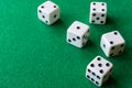 Top view of five dice, the first ones focused, on green mat, horizontally Royalty Free Stock Photo