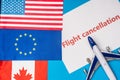 Top view of flags of canada, european union and america near toy plane with flight cancellation lettering