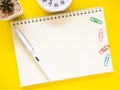 Top view, Flat lay, blank notebook on office yellow workplace tabletop with pen, clock, cactus. Copy space for your text. Royalty Free Stock Photo