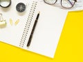 Top view, Flat lay, blank notebook on office yellow workplace tabletop with pen, keyboard, eyesglass, compass. Copy space for your