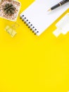 Top view, Flat lay, blank notepad on office yellow workplace tabletop with pen, hand sanitizer alcohol gel, cactus. Copy space for Royalty Free Stock Photo