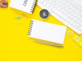 Top view, Flat lay, blank notepad on office yellow workplace tabletop with pen, keyboard, calendar, compass, cactus. Royalty Free Stock Photo