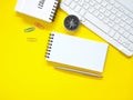 Top view, Flat lay, blank notepad on office yellow workplace tabletop with pen, keyboard, calendar, compass. Copy space for your t