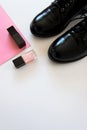 Top view flat lay of classic pair of black shoes and black and pink nail polishes Royalty Free Stock Photo