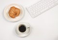 Flat lay of coffee cup ,croissant ,computer keyboard on white background with copy space. Morning working time concept Royalty Free Stock Photo