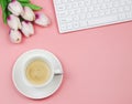 Flat lay of coffee cup   with tulip flower bouquet and computer keyboard on pink background with copy space for text. Feminine Royalty Free Stock Photo