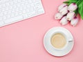 Flat lay of coffee cup   with tulip flower bouquet and computer keyboard on pink background with copy space for text. Feminine Royalty Free Stock Photo