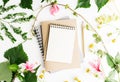 Top view flat lay empty note book with summer leaves and daisy flowers mockup