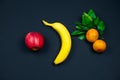 apple, banana and tangerines on a black background